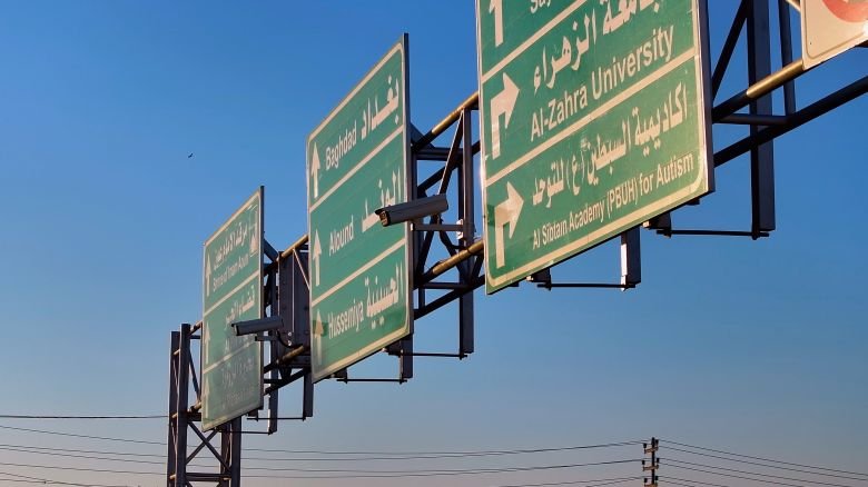 لوحات إرشادية خضراء تحدد اتجاهات الطرق والمؤسسات.