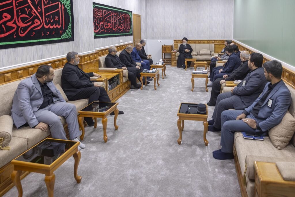 اجتماع رجل دين معمم بوفد في قاعة استقبال رسمية.