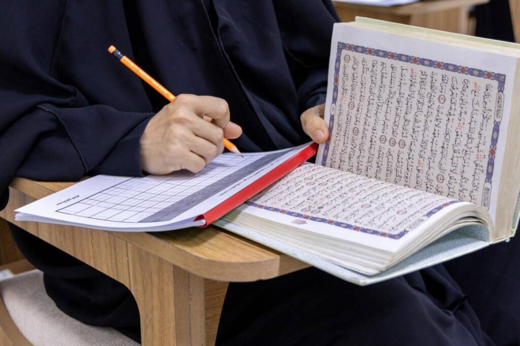 مشاركة تدوّن ملاحظات أثناء قراءة القرآن الكريم.
