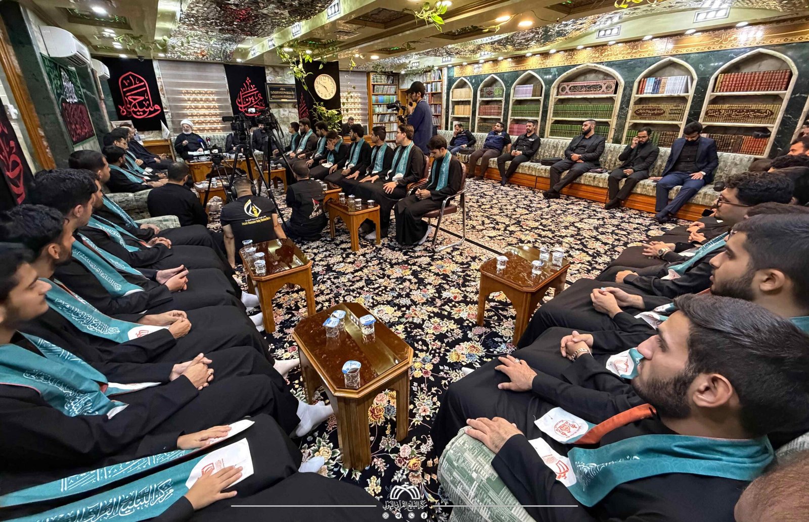 تجمع ديني داخل قاعة ممتلئة بالحضور.