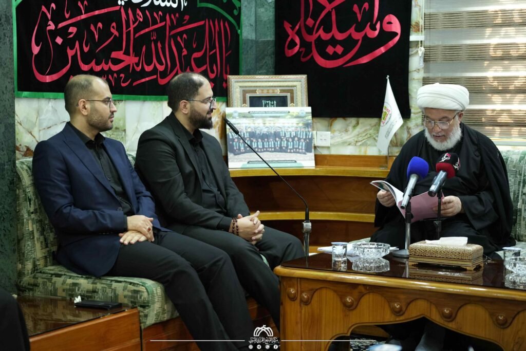 شيخ معمم يقرأ بحضور رجلين.