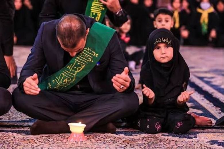 رجل وطفلة يرتديان الملابس السوداء ويدعوان معاً في مجالس العزاء.