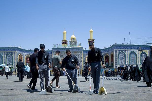 كوادر الخدمة ينظفون ساحة العتبة العباسية.