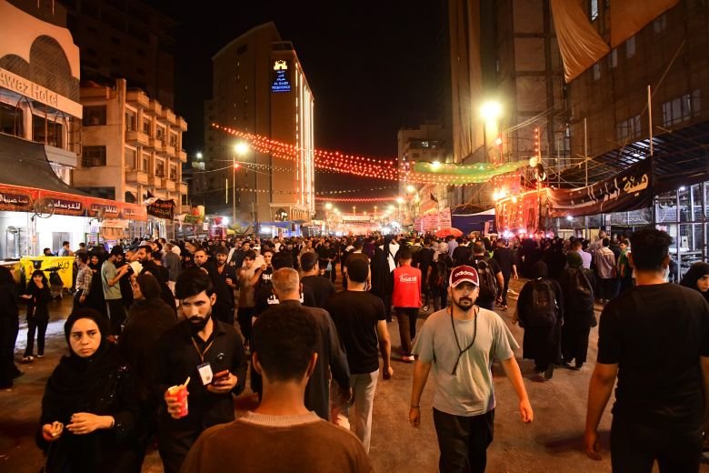 زوار يسيرون في أحد شوارع كربلاء ليلاً