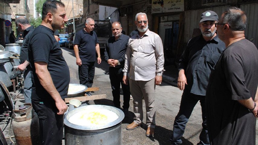 مجموعة من الرجال يتفقدون قدور الطعام الكبيرة في أحد شوارع السوق