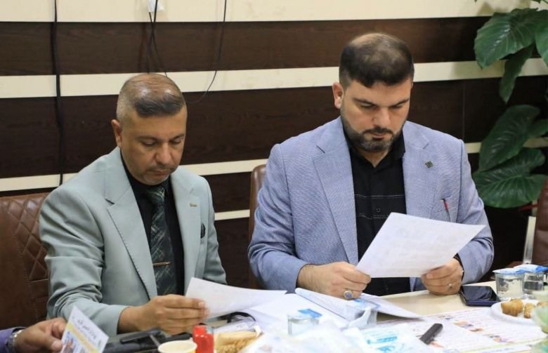 مسؤولان يراجعان وثائق رسمية خلال اجتماع تنسيقي داخل إحدى المؤسسات.