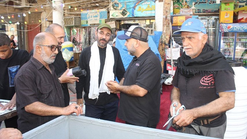 متطوعون يتحدثون بجوار موقع لتوزيع الطعام والمياه في السوق