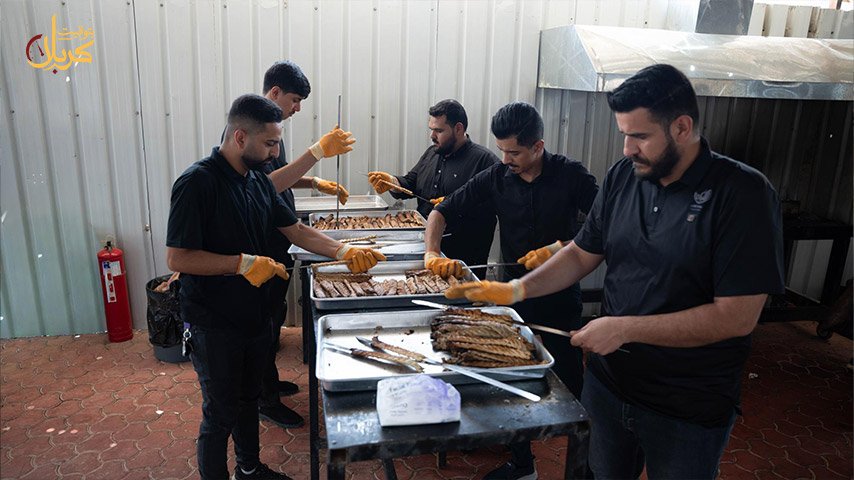 شباب يفرغون الكباب المشوي من الأسياخ في صوانٍ معدنية.