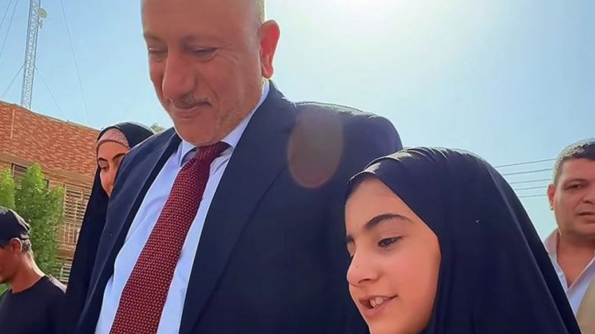 مسؤول يستمع لطفلة خلال جولة ميدانية في كربلاء المقدسة