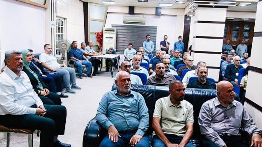 حضور يجلسون في قاعة اجتماعات يتابعون مجريات اللقاء.